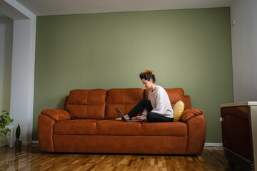 One woman sit on sofa bed at home work on the laptop computer