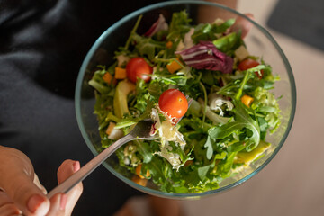 a person eating a full salad