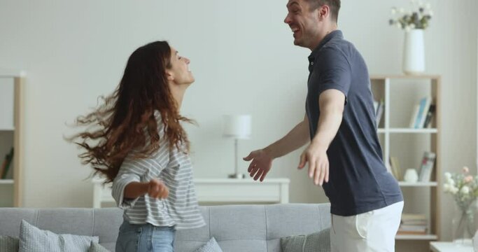 Funny overjoyed winners couple jumping, celebrating victory in lottery. Euphoric spouses get sms message read great news, feel unbelievable happy, looking excited about success, winning gift or prize