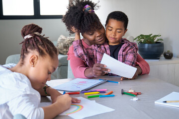 African mother painting with her son and niece during the freetime. Horizontal extended family.