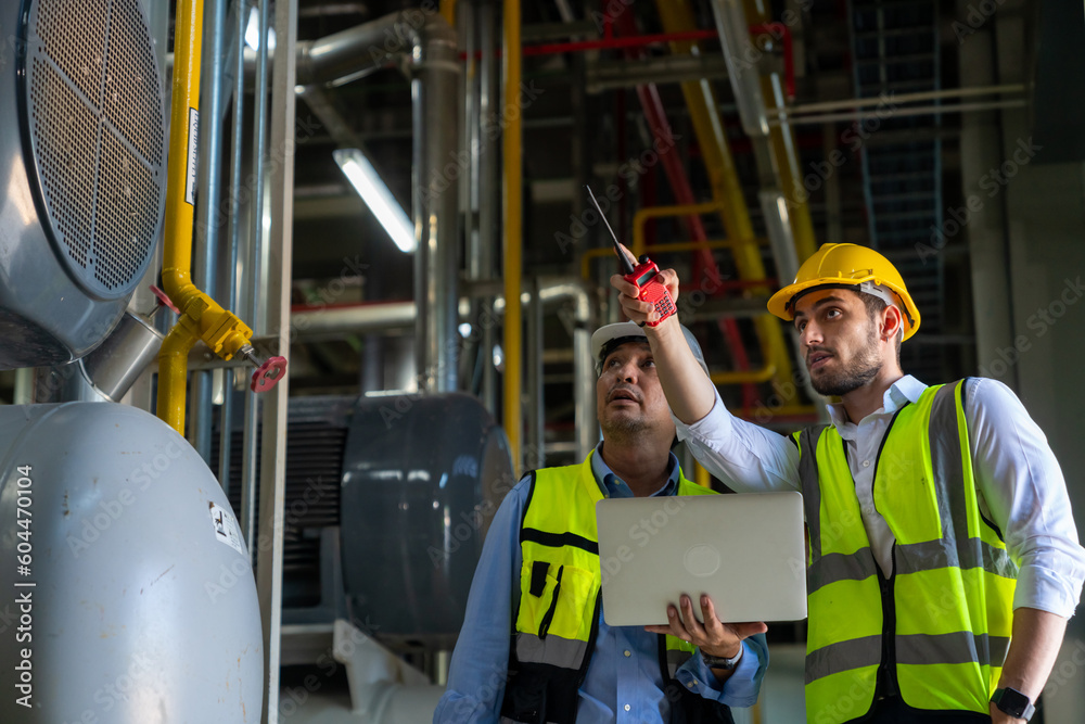 Wall mural two professional electrical engineer in safety uniform working together at factory site control room