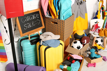 Many different stuff near white brick wall. Garage sale