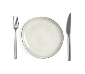 Clean plate and shiny cutlery on white background, top view