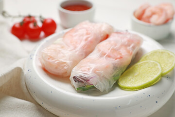 Delicious spring rolls with shrimps wrapped in rice paper on white wooden table, closeup