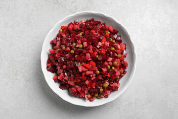 Delicious fresh vinaigrette salad on light grey table, top view