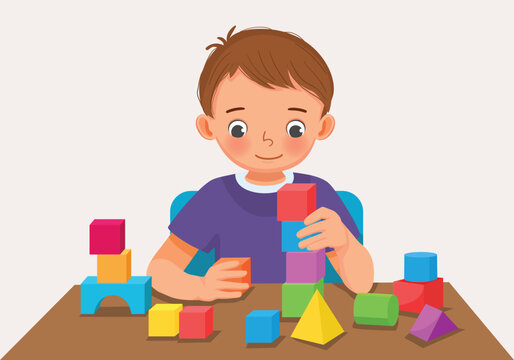 Cute little boy playing colorful wooden brick block toys at the table