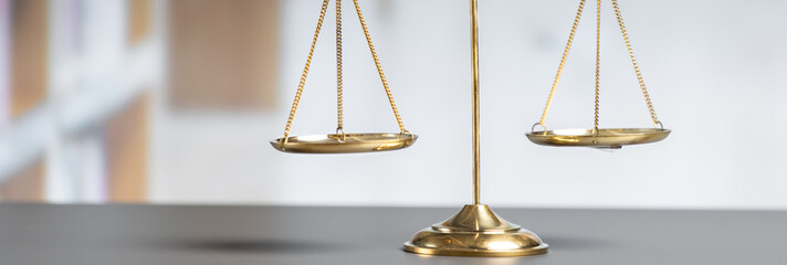Shiny golden balanced scale in court library background as concept justice and fairness legal...