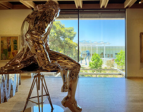 Sydney, NSW, Australia -Dec 28, 2022: A silver statue in an Exhibition hall at the Art Gallery of New South Wales in the old South Building looking out the window to the new gallery in Sydney.