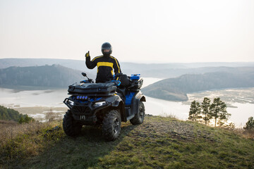 Happy man travel by ATV car on mountains.