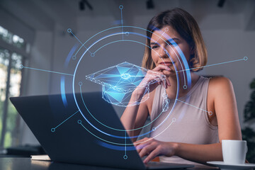 Thoughtful businesswoman in casual wear typing on laptop at office workplace with coffee cup....