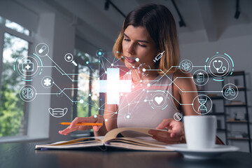 Smiling woman in casual wear taking notes in notebook at office workplace with coffee cup. Concept distant business education, information technology, dreaming, thinking. Health care medical drawings