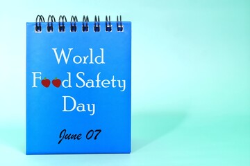 June 7 as World Food Safety Day date reminder on blue desk calendar. Celebration concept.	