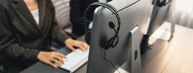 Panorama focus headset on call center workspace desk with blur background of operator team or telesales representative engage in providing client with customer support service or making sales. Prodigy - obrazy, fototapety, plakaty