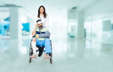 Young indian man with leg fractured after accident sitting on a wheelchair push by medical staff at...