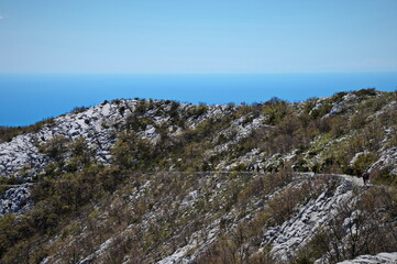 Fototapeta na wymiar Group of unrecognizable people hiking in karst landscape of Croatian mountains