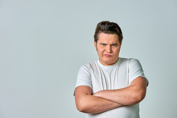 Angry, frowning man on a gray background, copy space