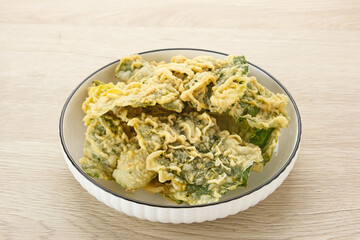 Keripik Bayam (Spinach Crackers) served on white plate. Indonesian traditional snack
