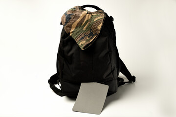 mochila negra para equipo de fotografía con gorro y carta de gris neutro para el campo 