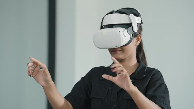 Young women wearing VR goggles posing finger touching on the air. Woman testing VR glasses or goggles working with virtual reality. Metaverse technology concept