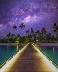 Foto auf Acrylglas Antireflex Luxury resort pier bridge with lights, sea ocean shore and beach at night sunset time, dreamy sky Milky Way over palm trees. Exotic adventure carefree travel vacation, summer landscape. Fantasy nature © icemanphotos