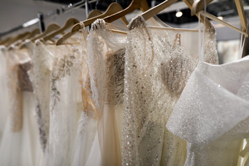 Shallow depth of field (selective focus) details with wedding dresses on display in a shop.