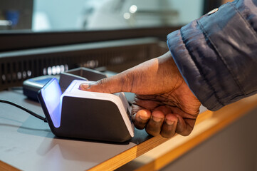Close up shot of biometrics being done on persons thumb