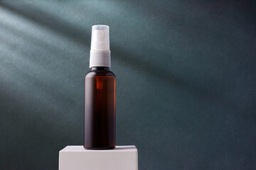 Naklejka premium Cosmetic brown bottle with sprayer on blue background