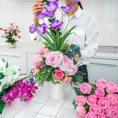 Arranging artificial flowers decoration at home, Young woman flo