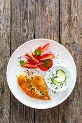 Seared chicken breast and tzatziki on wooden table