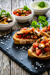Tasty sandwiches - toasted bread with tomatoes and clams  on wooden table
