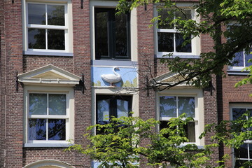 Fototapeta na wymiar Amsterdam Singel Canal House Facade Close Up with Sculpted Tablet Depicting a Goose, Netherlands