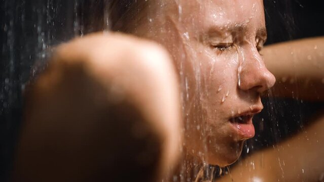 Young woman take shower with cold water in morning, fresh start day. Concept of heathy lifestyle, rejuvenation, water consumption problem, cheer up in morning, hygiene, self-care