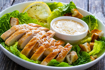 Caesar salad - fried chicken breast and vegetables on wooden table
 - obrazy, fototapety, plakaty