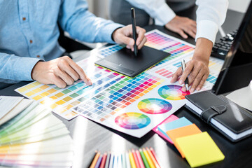 Team of creative graphic designer working on color swatch samples chart for selection coloring in inspiration to create new collection at workplace