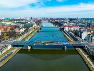 Bridges on Vistula River in Krakow, Poland. Aerial view. Boulevards with waking people. Blue...