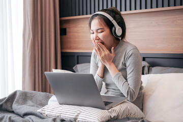 Young asian woman with headphone looking excited and covering he