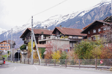 A street scene with a house and mountains in the background.
