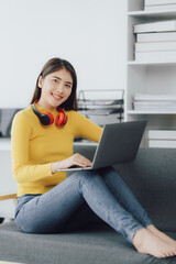 Asian woman enjoy listening to music and drinking coffee and laptop computer in the morning