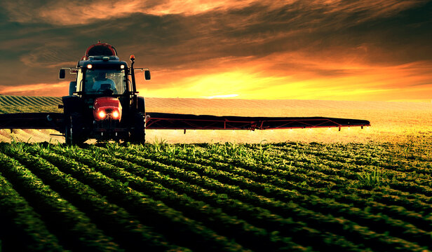 Tractor spraying soybean crops field