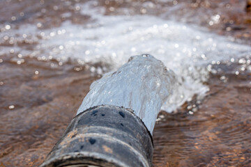 pump pipe water flow equipment agriculture, irrigation water from the source, water flow from large pump tube in farm