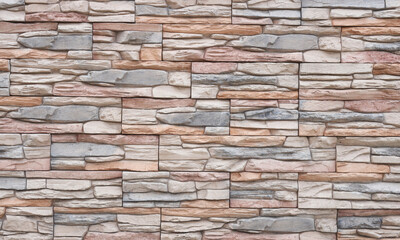 Obraz premium Artificial stone wall with uneven stones. Modern architecture concept idea