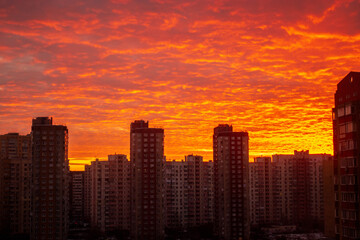 Fototapeta na wymiar Colorful sunset in red among the sleeping area of high-rise buildings