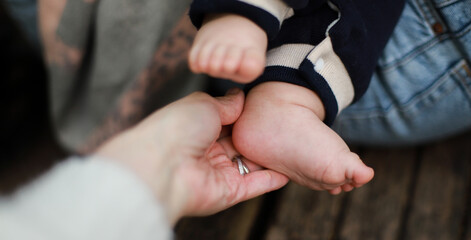 Banner The hand holds the baby is leg. Leg of a newborn. Kid on a walk