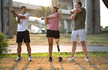 Exercise Asia woman with prosthetic leg and caucasian friend stretching at the park	city