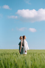 Two fashion woman in the green field. Fashion concept. Beautiful figures. Summer concept.