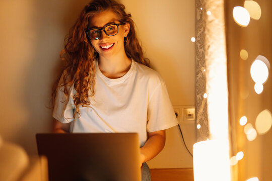 Young woman working online on laptop computer at home. Business, blogging, freelance, education concept.
