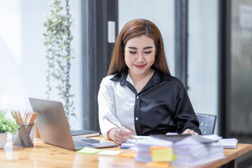 Business Asian woman working at office with documents on his desk, doing planning analyzing the financial report, business plan investment, finance analysis concept	