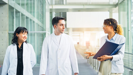 A multinational group having a conversation in the lobby.
People in white coats and sales staff.