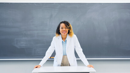 Female teacher teaching in front of the blackboard in the classroom.