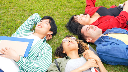 Multinational people lying on the lawn and looking up at the sky.